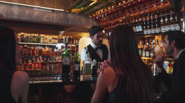 Dumanlı, klasik kokteyl içmiş çift ile VIP müşterilere özel içki servisi yapmak güzel kokuyor. İçki tezgahının lüks barında akıllı barmenlerin açtığı viski kokteyli. Vinosity.