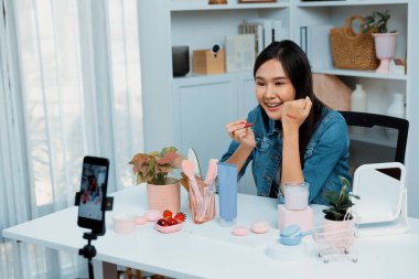 Genç, güzel Asyalı kozmetik makyaj ruju matte pastel rengini modern odadaki sosyal medyada kol testi tanıtımında en çok satanlar listesinde gösteriyor. Taktik.