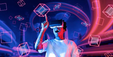 Afrikalı adam metaevrende oyun oynarken heyecanlı ve şekle bakıyor. Gündelik kıyafet öğrenme ve geleceğe dönük şehirde havada süzülen şekle bakma yeteneği olan zeki bir oyuncu. Teknoloji. Yaratıcılık.