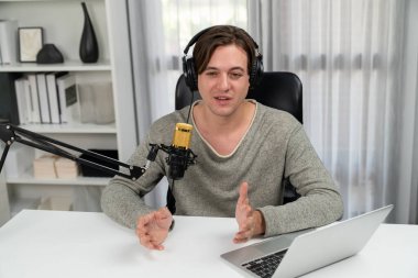 Sunucu kanalı, gülümseyen akıllı yayıncı kaydı, senaryosu ve akıllı telefonuyla sosyal medyada sohbet programı, kulaklık takarak modern ev stüdyosundaki video flamalarını kaydediyor. Bireysel.