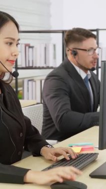 Ofiste çalışan kulaklık takan işadamları uzak müşteri ya da meslektaşlarını desteklemek için çalışıyorlar. Arama merkezi, tele pazarlama, müşteri destek acentesi telefon görüşmesinde hizmet sunar.