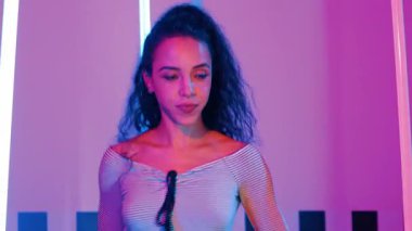 Stüdyoda mor ışıkla sokak dansı yapan İspanyol sokak dansçılarına yakın çekim. Profesyonel sanatçı şık kumaşla enerjik bir hareket sergiler. Çılgın, komik. Yarı vücut. Mutluluk.