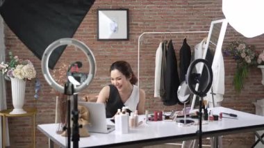 Kadın nüfuzlu kişi sosyal medya ya da blog için canlı yayın yapan video klip eleştirmeni derisini çekiyor. Canlı kozmetik stüdyosu ışıklandırması olan mutlu genç bir kız pazarlama için internet üzerinden yayın yapıyor..