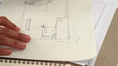 Ölçüm ve yazma aracını kullanarak mimari ofisindeki inşaat doğruluğu için ayrıntılı bir plan tasarlayan akıllı mimar ya da akıllı mühendisin videosu. Eline odaklan. - Yakın çekim. Tanımlama.