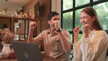 Gençler, kafeteryadaki baharda laptopta başarılı bir şekilde çalıştıktan sonra kutlama yapıyorlar. Uzaktan çalışan ya da blog yazan dijital göçebe ya da üniversite öğrencisi. Yararlı