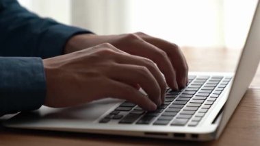 İşadamı ofis masasındaki becerikli dizüstü bilgisayarda elle çalışıyor. Bilgisayarın klavyesini yazarken ve çalışırken yakın çekim ve seçici odaklanma.