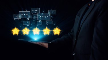 Bir iş adamı, müşteri memnuniyetini ve hizmet kalitesinin modern etkileşimlerdeki önemini sembolize eden, parlayan yıldızlar ve geri bildirim simgeleriyle dolu bir tablet sunar. Dörtgen