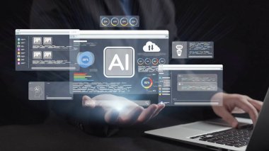 Bir iş adamı karanlık bir ortamda birden fazla ekranda gelişmiş yapay zeka, veri analizi ve modern teknolojinin etkileşimli dijital arayüzlerini keşfeder. Dörtgen