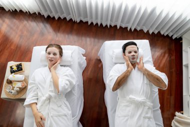 Kaplıca salonunun sakin, modern gündüz atmosferi, birkaç müşteri yüz maskesi takarak kendini yenilemeye çalışıyor. Yüz bakımı ve güzellik kozmetolojisi prosedürü. Sessiz.