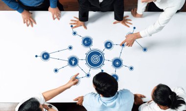 Çeşitli iş adamları dijital bir strateji üzerinde işbirliği yaparak, masadaki hedef simgeleri analiz ederek, takım çalışmalarını ve şirket ortamındaki yenilikleri sergiliyor. Dostluk