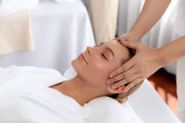 Kafkasyalı kadın stres önleyici kafa masajından ve lüks tatil beldesi ya da otel spa salonundaki modern ışık ortamında yüz güzelliği eğlencelerini şımartmaktan hoşlanıyor. Sessiz.