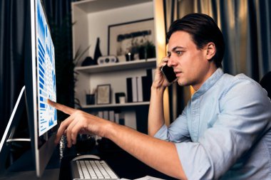 Akıllı iş adamı, akıllı telefonuyla iş paragrafı dinamik veri tabanı pazarlama analizine danışmak için arıyor. Gece vakti merkez ofisteki bilgisayar monitörü kanal satış raporuna işaret ediyor. Bireysel.