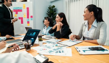 Ofis masasındaki finansal veri raporlarını analiz eden çeşitli bir grup iş analisti. Stratejik pazarlama planlaması için iş istihbarat analizine göre grafikler ve grafikler.