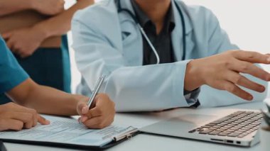 Hasta için hastane masasında çalışan ve tıbbi tedavi planlayanlardan oluşan profesyonel bir ekip. Takım çalışması başarılı hastalıklara ve hastalıklara yol açar. Ağır çekim. Katı.