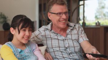 Büyükbaba ve torun birlikte TV 'de ilginç bir eğlence medyası izliyorlar. Eski üst düzey kullanım teknolojisi, genç nesil çapraz nesil ile iletişim kurarak aile bağlarını güçlendiriyor. Uyumsuzluk.