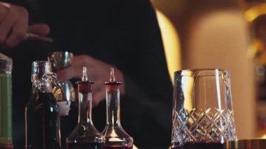 İçki şekerini ölçmek için elinde jigger tutan yakın el barmeni bardakları karıştırmak için alkol hazırlama yaratıcı karışım. Gece hayatı karışımı sergilenen özel bir içecek. Vinosity.