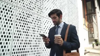 Akıllı iş adamı iş yatırımları hakkında konuşmak için telefonu kullanıyor. İş planı, pazarlama stratejisi ya da çalışma hakkında konuşmak için akıllı telefonla konuşurken sokakta yürüyen mutlu bir yönetici. Sevinçli..