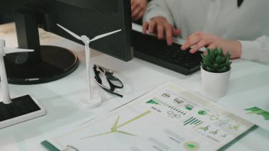 Çeşitli bir ekip modern bir ofis masasında fikir üretmek ve iş büyümesini etkin bir şekilde stratejileştirmek için teknoloji, çizelge ve belgelerle uğraşır. SACTR