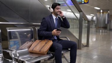 Tren istasyonunda oturmuş müzik dinleyen yetenekli bir iş adamı. Profesyonel Kafkas proje yöneticisi tren ya da metro bekliyor. Erkek lider dinlemekten hoşlanır. Takım elbiseli rahat müzik. Sevinçli..