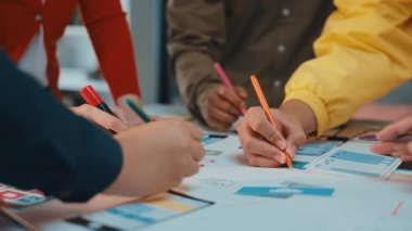 Çeşitli profesyonellerden oluşan bir grup, modern bir ofiste yenilikçi iş stratejileri geliştirmek için dijital araçlar ve kağıt materyaller kullanıyor. SACTR