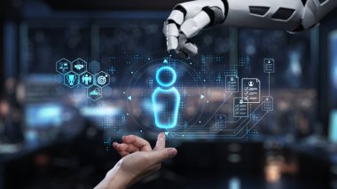 Robotik bir el, gelecekteki çalışma alanındaki dijital bir insan figürüne ulaşarak teknoloji, yenilik ve insan-bilgisayar etkileşimi temalarını sergiliyor. Auvana