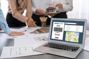 İç mimar tasarımcı grubu, daha kesin tasarım için planlar ve dizüstü bilgisayar ekran mimari yazılımı üzerinde birlikte tartışıyorlar. Modern ev tasarımı ve yenileme. İçgörü