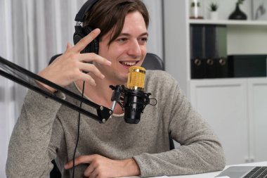 Sunucu kanalı, gülümseyen akıllı yayıncı kaydı, senaryosu ve akıllı telefonuyla sosyal medyada sohbet programı, kulaklık takarak modern ev stüdyosundaki video flamalarını kaydediyor. Bireysel.