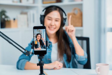 Yaratıcı yayıncı genç ve güzel Asyalı 'nın sunucu kanalındaki seçici odaklı telefon stüdyodaki dinleyiciyle günlük hayatta pazarlamayı veya danışmanı desteklemek için online olarak konuşuyor. Taktik.