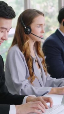 Ofiste çalışan kulaklık takan işadamları uzak müşteri ya da meslektaşlarını desteklemek için çalışıyorlar. Arama merkezi, tele pazarlama, müşteri destek acentesi telefon görüşmesinde hizmet sunar.