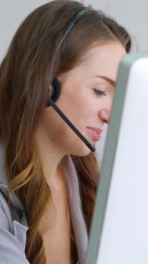 Ofiste çalışan kulaklık takan işadamları uzak müşteri ya da meslektaşlarını desteklemek için çalışıyorlar. Arama merkezi, tele pazarlama, müşteri destek acentesi telefon görüşmesinde hizmet sunar.