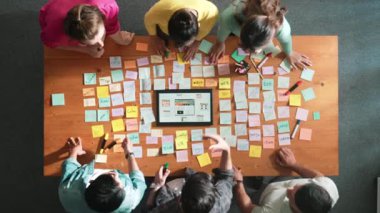 Ux Ui tasarımı kullanılarak dijital program ve yazıları tartışan ve gösteren geliştirici ekibin hava görüntüsü. İş dünyasına tepeden bakan insanlar telefon ve bilgisayar için kablo prototipi geliştiriyorlar. Sempozyum.