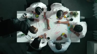 Yetenekli iş adamlarının zihin haritası kullanarak beyin fırtınası yapmak için birlikte çalışmaları zaman aşımı. Yetenekli yöneticinin sürdürülebilir enerji hakkında konuşup tartışmasının havadan görüntüsü. Hizalama.