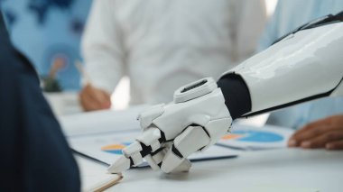Gösterişli bir robot el modern bir ofiste belge ve analiz çizelgeleri ile etkileşime girer, yenilikleri ve teknolojinin ticari işbirliğindeki rolünü simgeler. Noogenesis