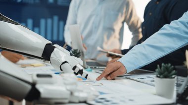 Robot ve insan arasındaki işbirlikçi etkileşimin yer aldığı, teknolojilerin veri analizi ve stratejik iş gelişiminde rol oynadığı modern bir çalışma alanı sahnesi.