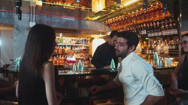 VIP grubu, barın önünde oturmuş arkadaşlarıyla ya da barmen hazırlarken karışık punç kokteyli içen çiftle yaşam tarzı seyahatlerini tartışıyor tezgahın üzerinde arka taraftaki süslü Noel ağacını hazırlıyor. Vinosity.