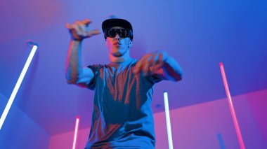 Beyaz dansçının gösterişli gözlükler taktığı ve break dans yaptığı alçak açılı kamera. Çekici adam kendinden emin bir şekilde kameraya bakarken enerjik bir performans ve hareket gösterdi. Mutluluk.