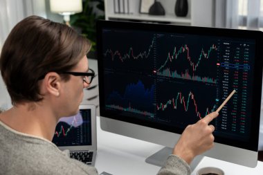 Akıllı yatırımcılar bilgisayar ekranlı ilginç borsa takasını işaret ediyorlar. Finansal teknoloji dinamik yatırım planı modern işyerindeki veri grafiğine odaklanıyor. Bireysel.