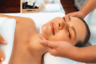 Kafkasyalı kadın stres önleyici kafa masajından ve lüks tatil beldesi ya da otel spa salonundaki modern ışık ortamında yüz güzelliği eğlencelerini şımartmaktan hoşlanıyor. Sessiz.