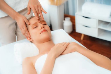 Kafkasyalı kadın stres önleyici kafa masajından ve lüks tatil beldesi ya da otel spa salonundaki modern ışık ortamında yüz güzelliği eğlencelerini şımartmaktan hoşlanıyor. Sessiz.