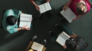 İncil 'i okuyup, kucağında İncil' le daireler çizerek otururken en tepeden aşağı dua manzarası. İnanç, güven ve umut ve sükunetle çalışırken farklı insanların kitaba bakışları. Sempozyum.