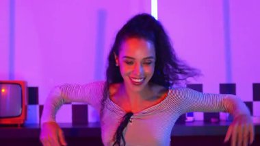 Stüdyoda mor ışıkla sokak dansı yapan İspanyol sokak dansçılarına yakın çekim. Profesyonel sanatçı şık kumaşla enerjik bir hareket sergiler. Çılgın, komik. Yarı vücut. Mutluluk.