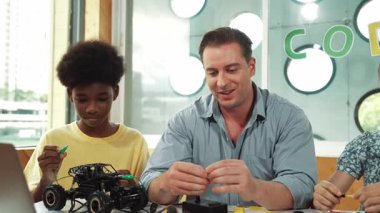 Yetenekli öğretmen çeşitli öğrencilere kablo ve elektronik ekipman kullanarak araba modelini tamir etmeyi öğretiyor. Bilgisayara bakarken ana kartı kontrol etmek için elektrikli alet kullanmayı öğrenen bir kız. Öğretim