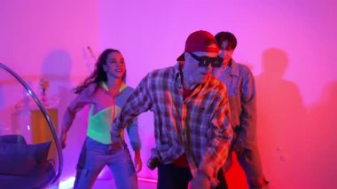 Çeşitli arkadaşlarla sokak dansı pratiği yapan profesyonel break dansçı. Çok kültürlü mutlu insanlar modern dans ederken şık giysiler giyer veya hippi tarzı dans ederler. Neon ışığı. Mutluluk.