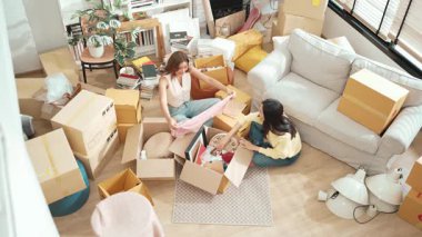 Kutuları açan ve mobilyaları toplayan mutlu arkadaş manzarası. Karton kutuyla çevrili oturma odasında konuşurken yeni daireye taşınan çekici bir genç. Malikane. Myrmidon.