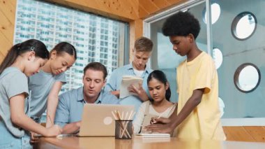 Akıllı robotlar sınıfta dizüstü bilgisayar ekranını işaret ederken, beyaz bir öğretmen yorum yapıyor ya da öğrencilere tavsiye veriyor. Öğretmen bilgisayar kullanırken çeşitli öğrencilerin ders verirken not alması. Öğretim