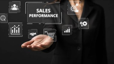 Bir iş adamı çeşitli dijital pazarlama performans ölçümlerini gösteren bir el sunarak, veri analizlerinin satış etkinliğinin artırılmasındaki önemini vurguladı. XDMCP