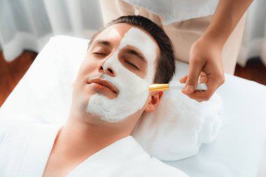 Kaplıca salonunun sakin atmosferi, insan müşterisi modern gün ışığında lüks yüz kremi masajıyla kendini yenileme zevkine kapılıyor. Yüz bakımı ve güzellik konsepti. Sessiz.