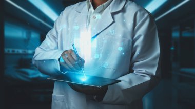 Stylus kalemle laboratuvarda yüzen tıbbi çapraz hologramı işaret ederken, doktorun tableti tutuş şeklini kapat. Pratisyen hekim teknolojiyi kullanarak ikonu kontrol ediyor ve bakıyor. İyileştirici.