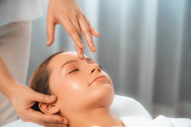 Kafkasyalı kadın stres önleyici kafa masajından ve lüks tatil beldesi ya da otel spa salonundaki modern ışık ortamında yüz güzelliği eğlencelerini şımartmaktan hoşlanıyor. Sessiz.