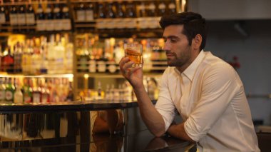 Beyaz tişörtlü, kokteyl içen zeki bir adam. Eski moda parti içkisi. Arkadaşlarını ya da çiftlerini cuma gecesi kulüpte bekleyen lüks bir tezgah barda bekliyor. Vinosity.